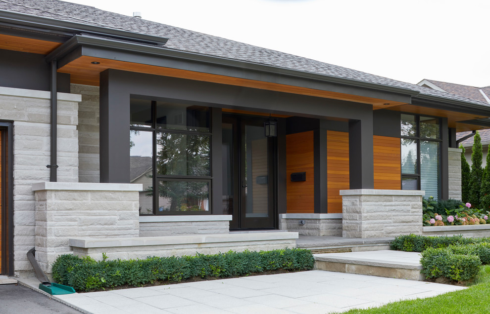 Design ideas for a medium sized modern front veranda in Toronto with a potted garden, natural stone paving and a roof extension.