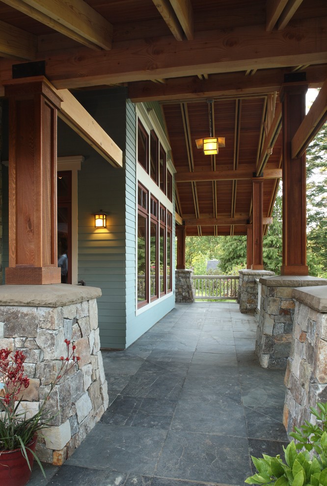 Idee per un portico stile americano di medie dimensioni e nel cortile laterale con un focolare, pavimentazioni in pietra naturale e un tetto a sbalzo