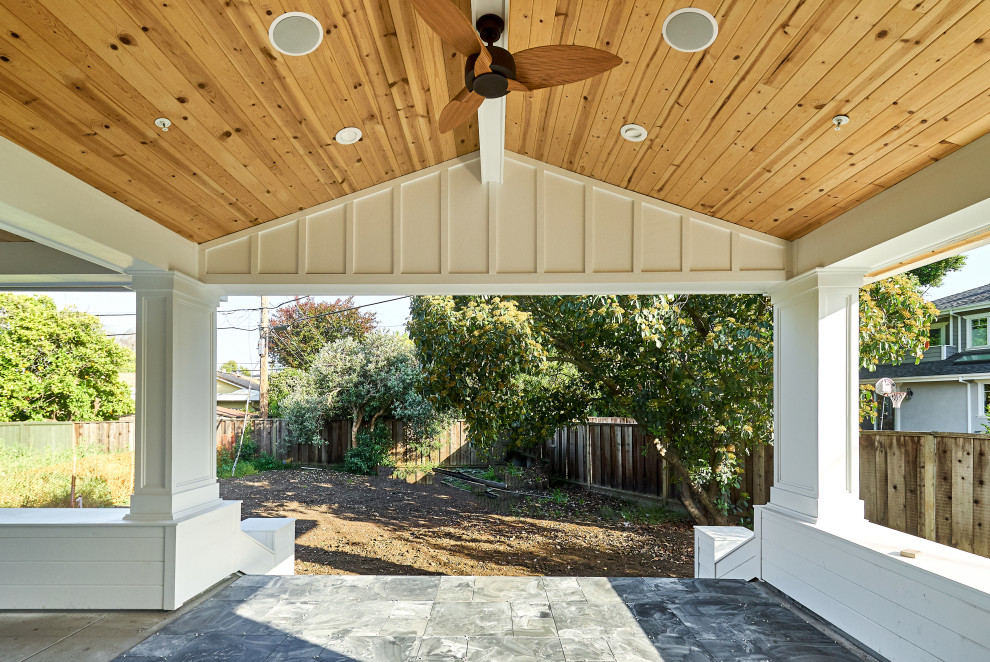 Idee per un grande portico american style dietro casa con pavimentazioni in cemento e un tetto a sbalzo