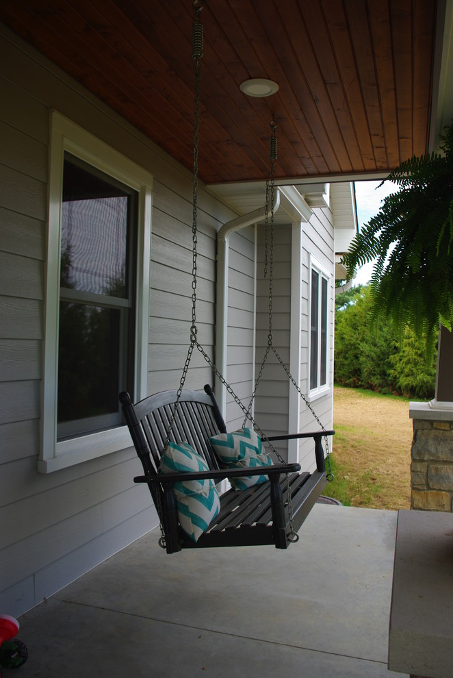Réalisation d'un grand porche d'entrée de maison avant champêtre avec une extension de toiture et une dalle de béton.