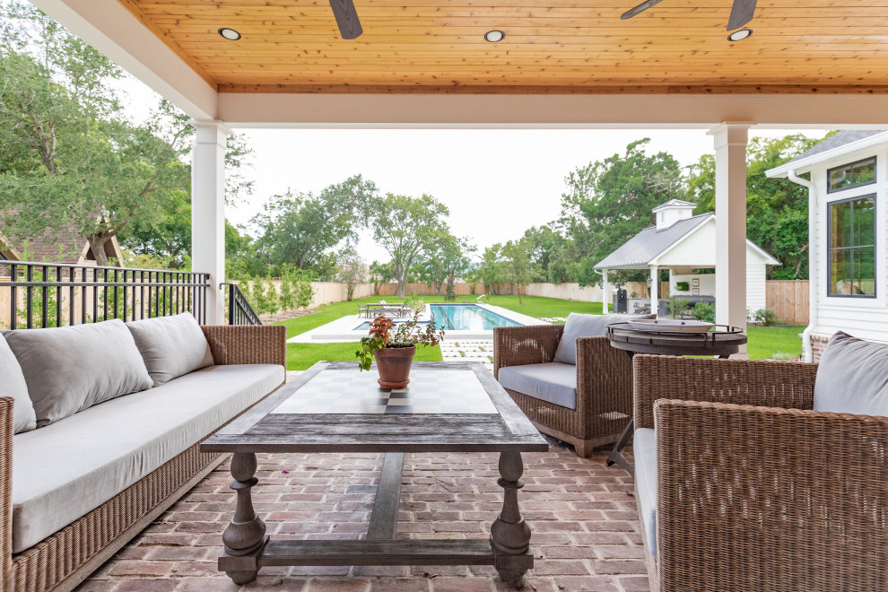 Réalisation d'un grand porche d'entrée de maison arrière champêtre avec des pavés en brique et une extension de toiture.