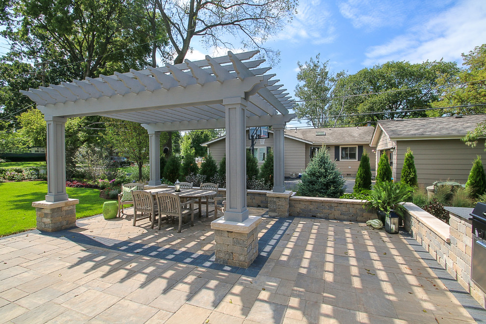 Immagine di un grande patio o portico country dietro casa con pavimentazioni in mattoni e una pergola