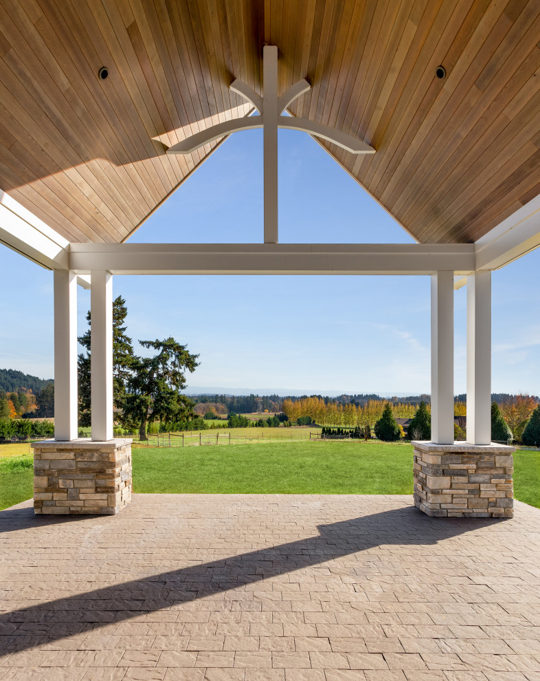 Idée de décoration pour un grand porche d'entrée de maison arrière design avec des pavés en béton et une extension de toiture.