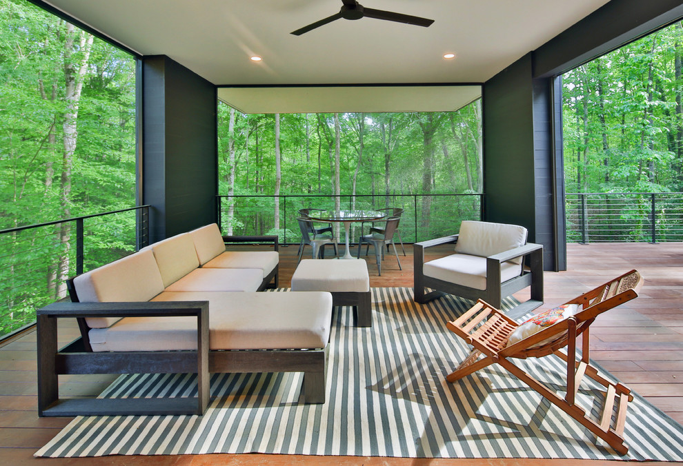 Inspiration for a modern screened-in back porch remodel in Raleigh with decking and a roof extension