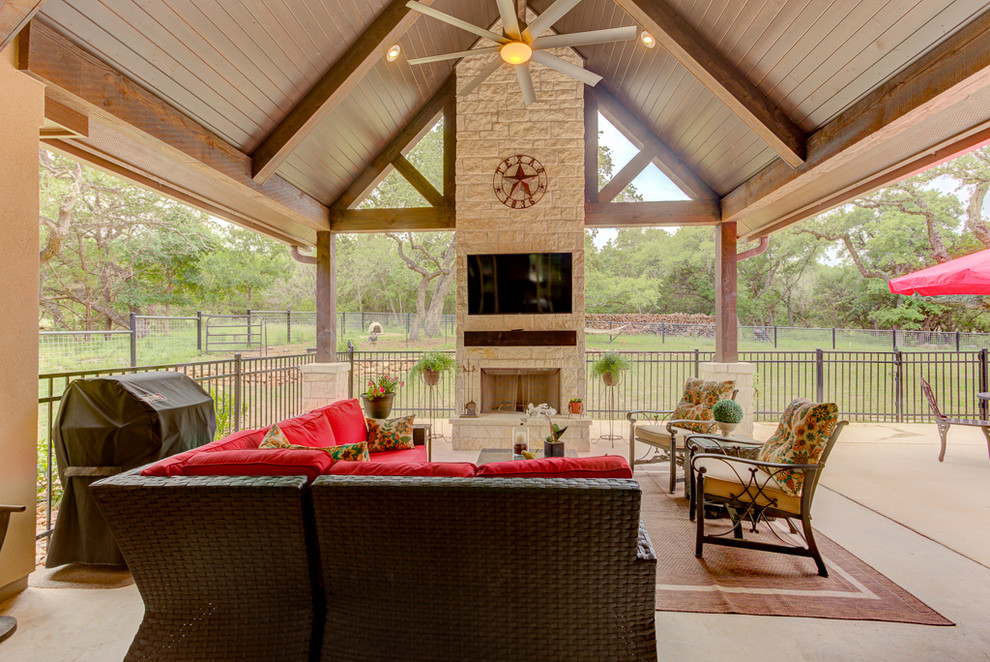 Medium sized rustic back veranda in Austin with a fireplace, concrete slabs and a roof extension.