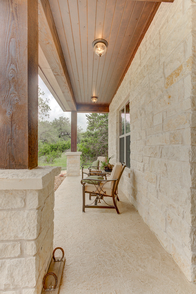 This is an example of a mid-sized rustic concrete front porch design in Austin with a fireplace and a roof extension.