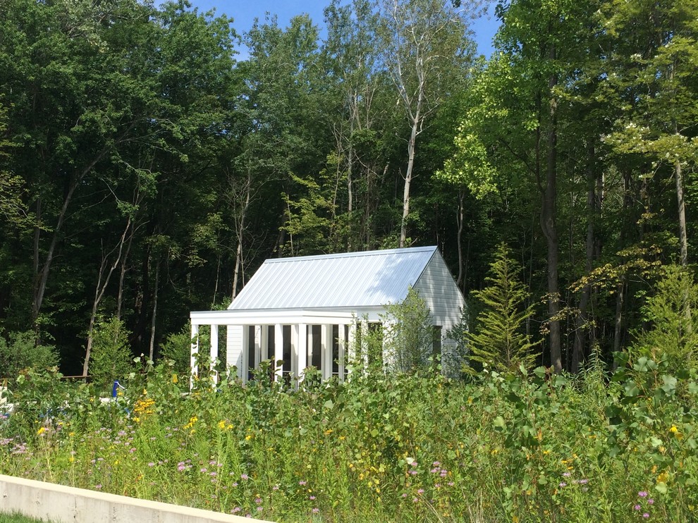 Aménagement d'un porche d'entrée de maison arrière campagne de taille moyenne avec une dalle de béton et une extension de toiture.