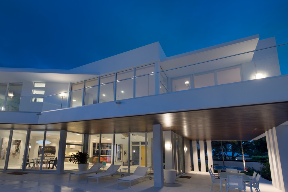 Cette photo montre un grand porche d'entrée de maison arrière moderne avec une extension de toiture.