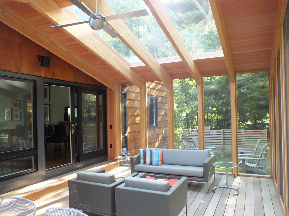 Idéer för att renovera en mellanstor funkis innätad veranda på baksidan av huset, med trädäck och takförlängning