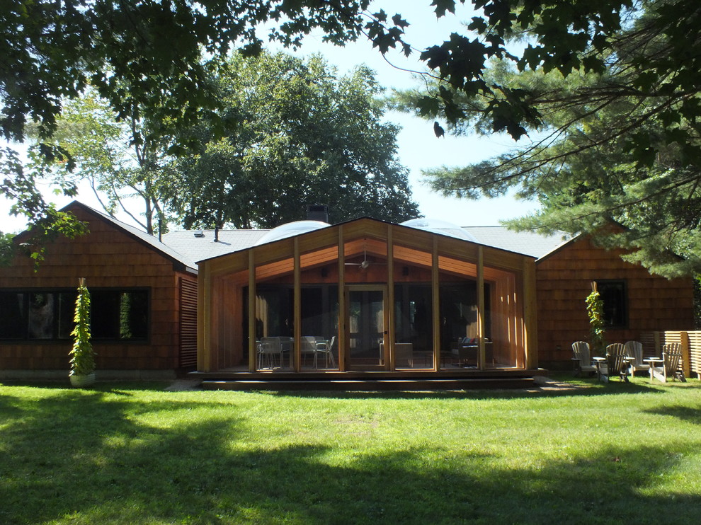Cette photo montre un porche d'entrée de maison arrière moderne de taille moyenne avec une moustiquaire, une terrasse en bois et une extension de toiture.