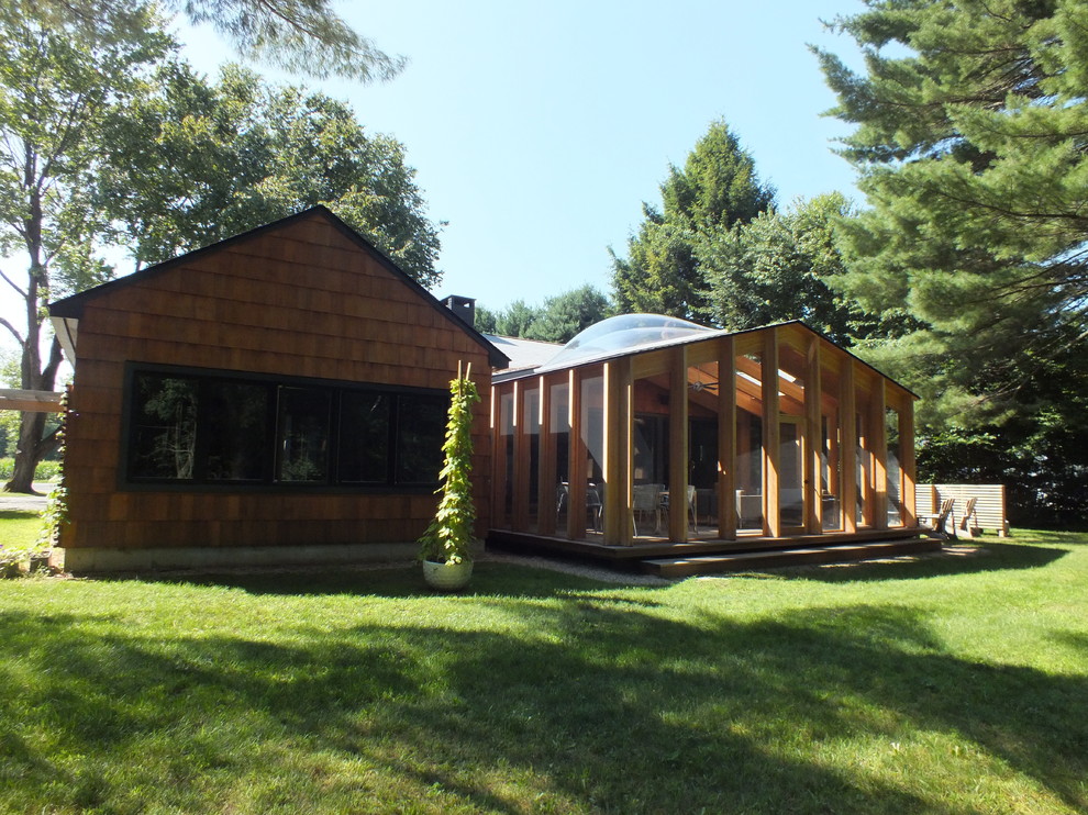 Réalisation d'un porche d'entrée de maison arrière minimaliste de taille moyenne avec une moustiquaire, une terrasse en bois et une extension de toiture.