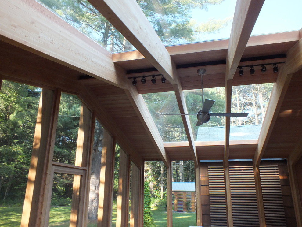 Inspiration for a mid-sized modern screened-in back porch remodel in Boston with decking and a roof extension