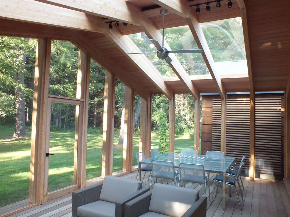 Cette photo montre un porche d'entrée de maison arrière moderne de taille moyenne avec une moustiquaire, une terrasse en bois et une extension de toiture.