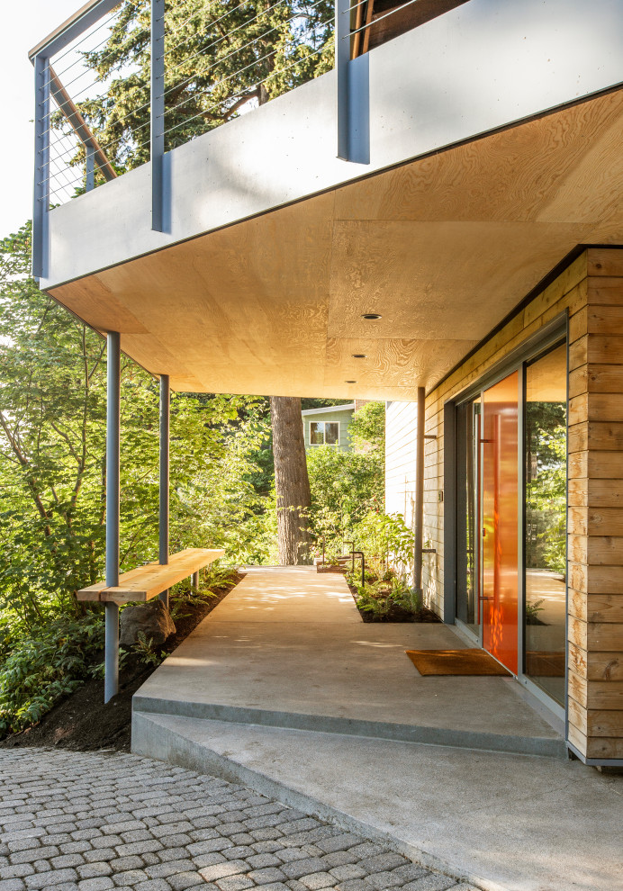 Idées déco pour un porche d'entrée de maison avant rétro de taille moyenne avec des colonnes, une dalle de béton et une extension de toiture.