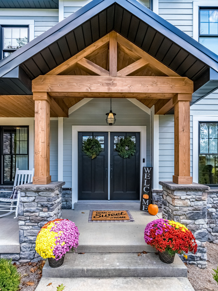 Idées déco pour un grand porche d'entrée de maison avant craftsman avec une dalle de béton et une extension de toiture.