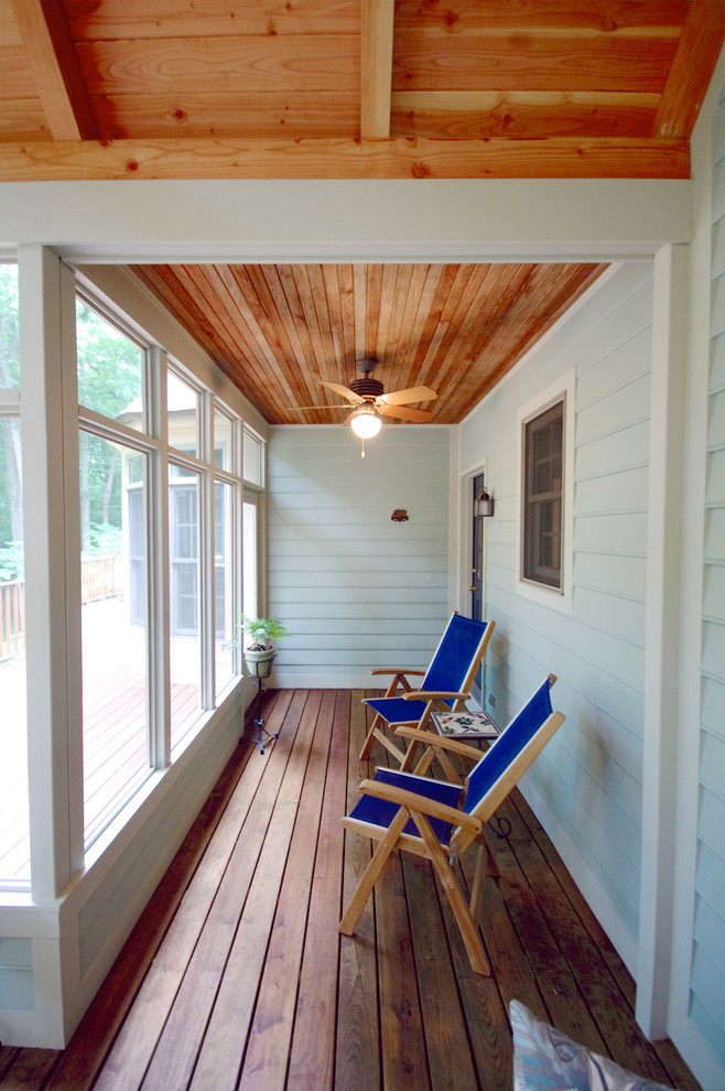This is an example of a large traditional screened-in back porch design in Baltimore.