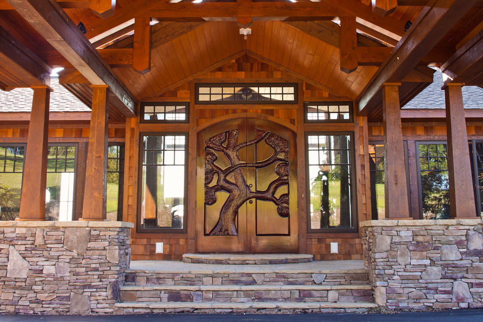 Cette image montre un porche d'entrée de maison avant chalet de taille moyenne avec des pavés en pierre naturelle et une extension de toiture.