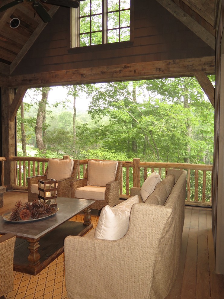 Idées déco pour un grand porche d'entrée de maison arrière montagne avec un foyer extérieur, une terrasse en bois et une extension de toiture.