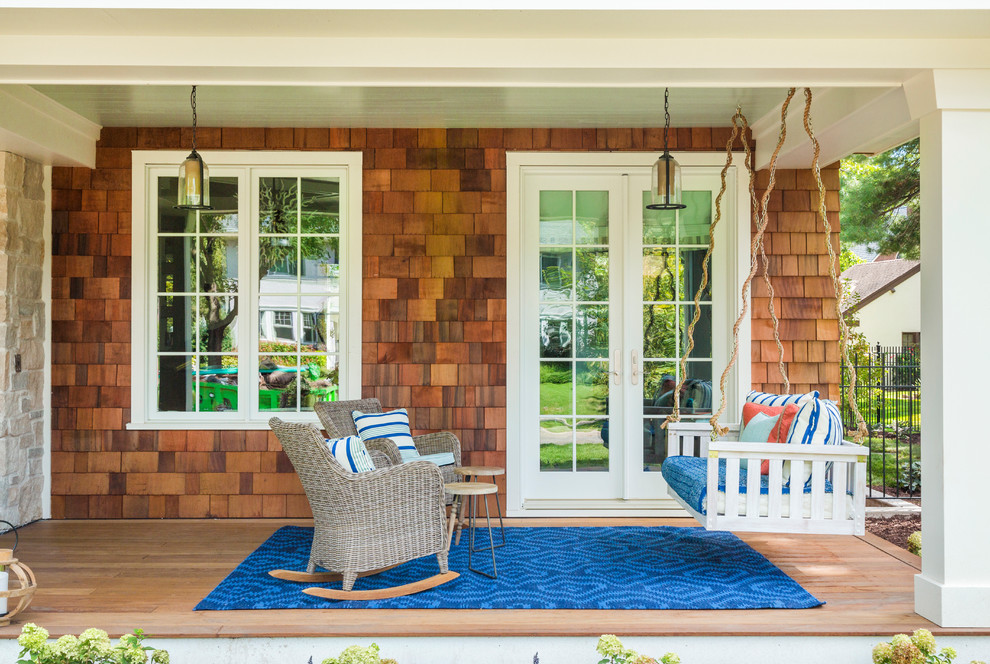 Cette photo montre un porche d'entrée de maison chic avec une terrasse en bois et une extension de toiture.