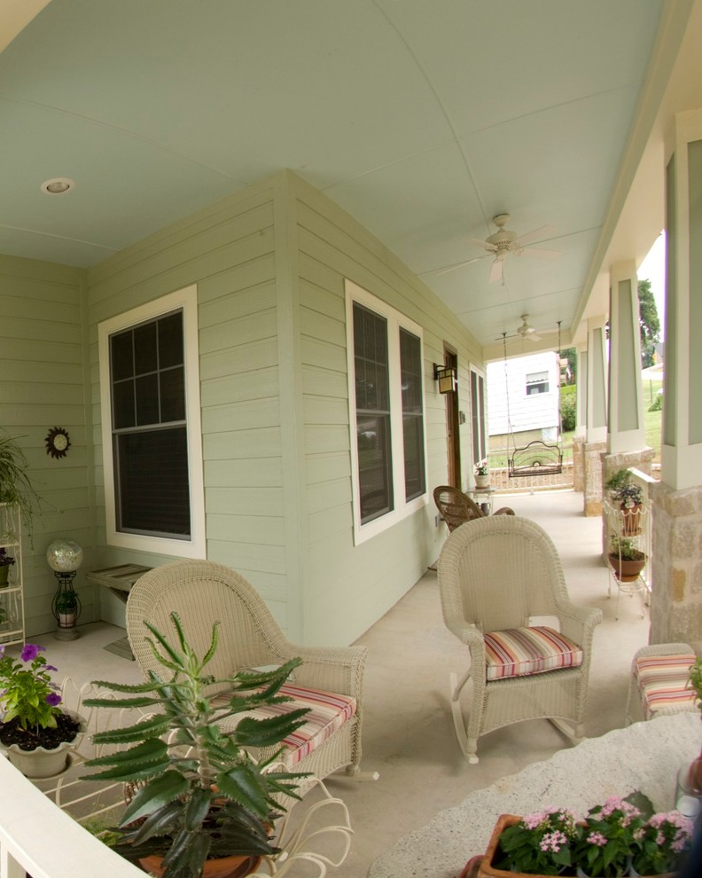 Idées déco pour un porche d'entrée de maison avant craftsman de taille moyenne avec une dalle de béton et une extension de toiture.