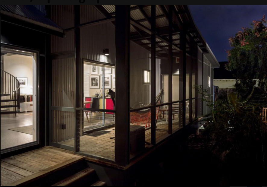 Industriell inredning av en mellanstor innätad veranda längs med huset, med trädäck och takförlängning