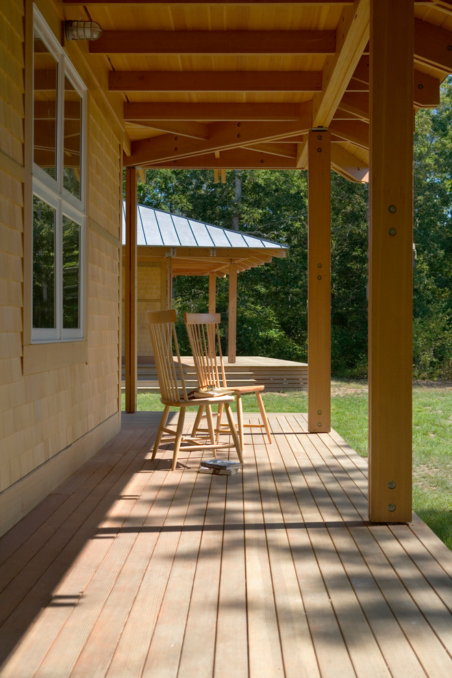 This is an example of a farmhouse veranda in Boston with a roof extension.