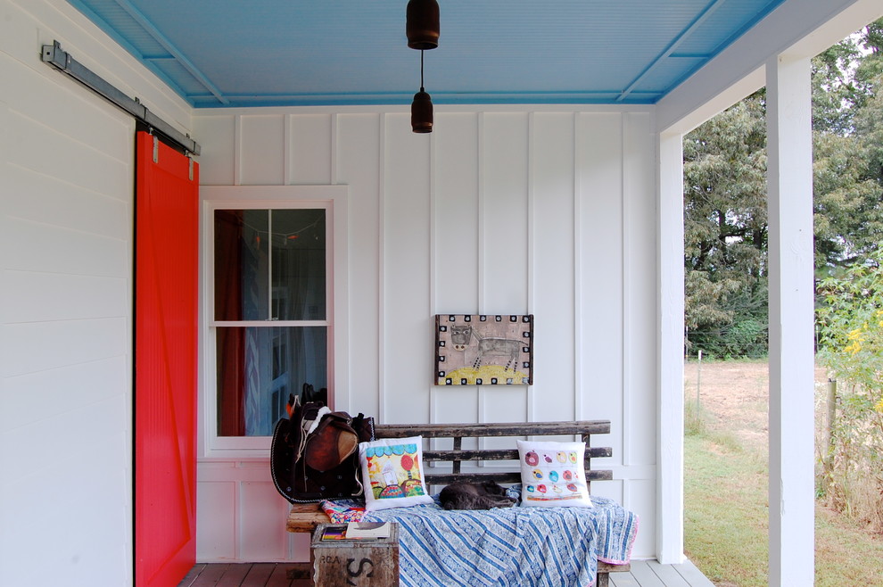 This is an example of a country porch design in New York with decking and a roof extension.