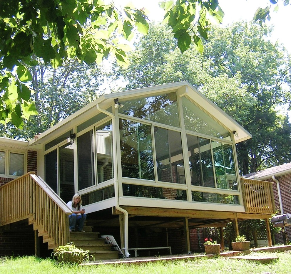 Diseño de porche cerrado tradicional de tamaño medio en patio trasero y anexo de casas con entablado