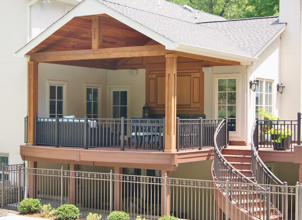 Idee per un ampio portico stile americano dietro casa con un focolare, pavimentazioni in mattoni e un tetto a sbalzo