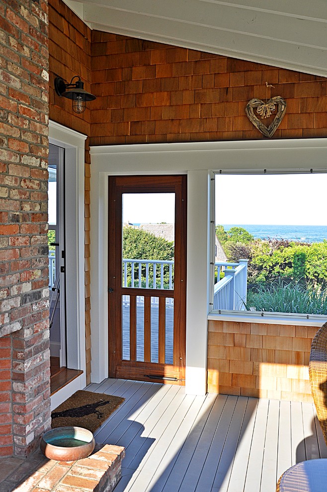Exemple d'un porche d'entrée de maison latéral bord de mer avec une moustiquaire et une extension de toiture.