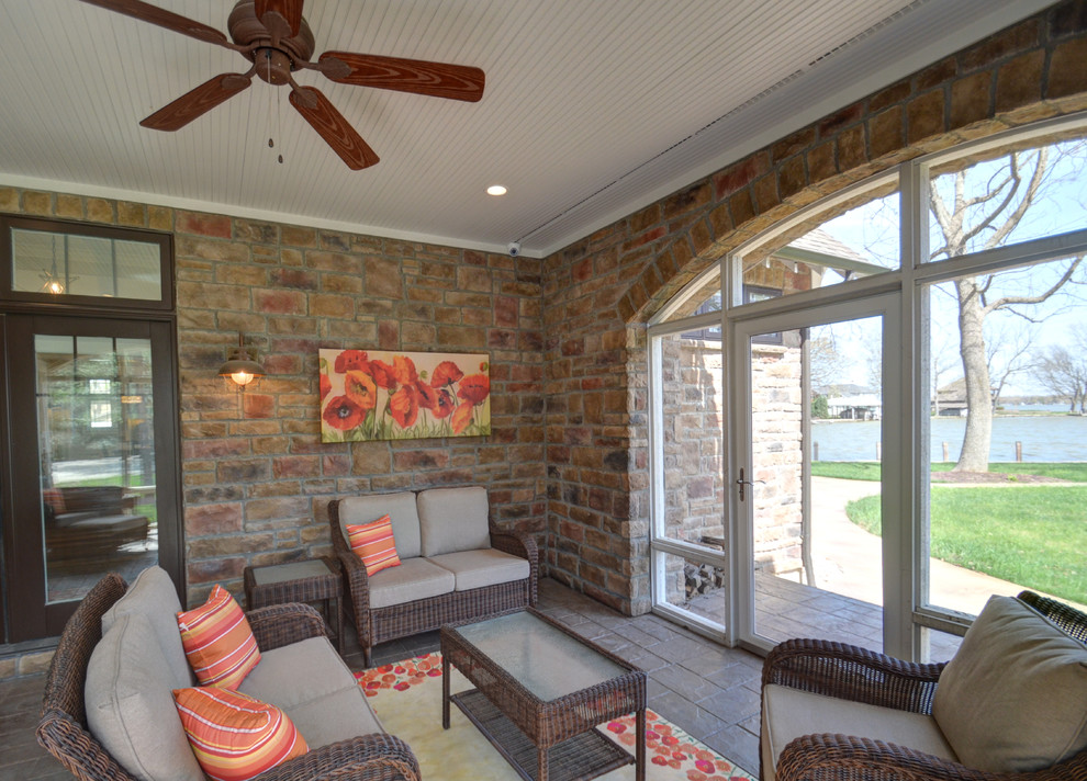 Inspiration for a side screened veranda in Columbus with stamped concrete and a roof extension.
