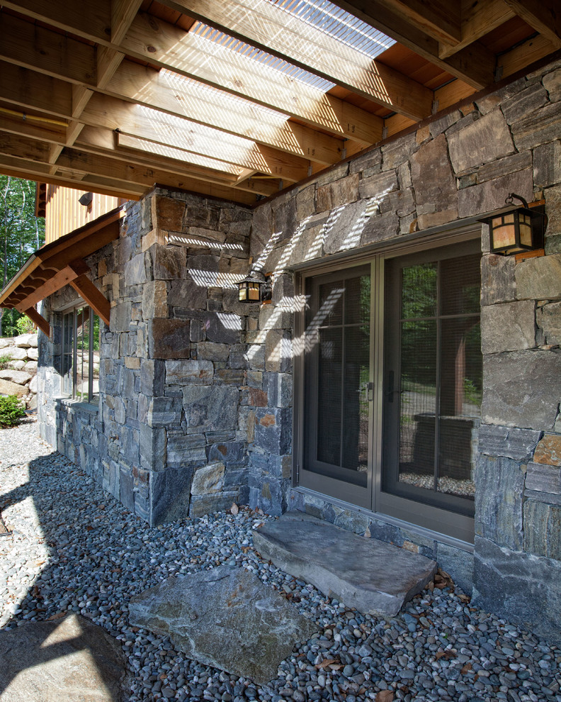 Immagine di un portico stile rurale di medie dimensioni e dietro casa con pavimentazioni in pietra naturale e una pergola