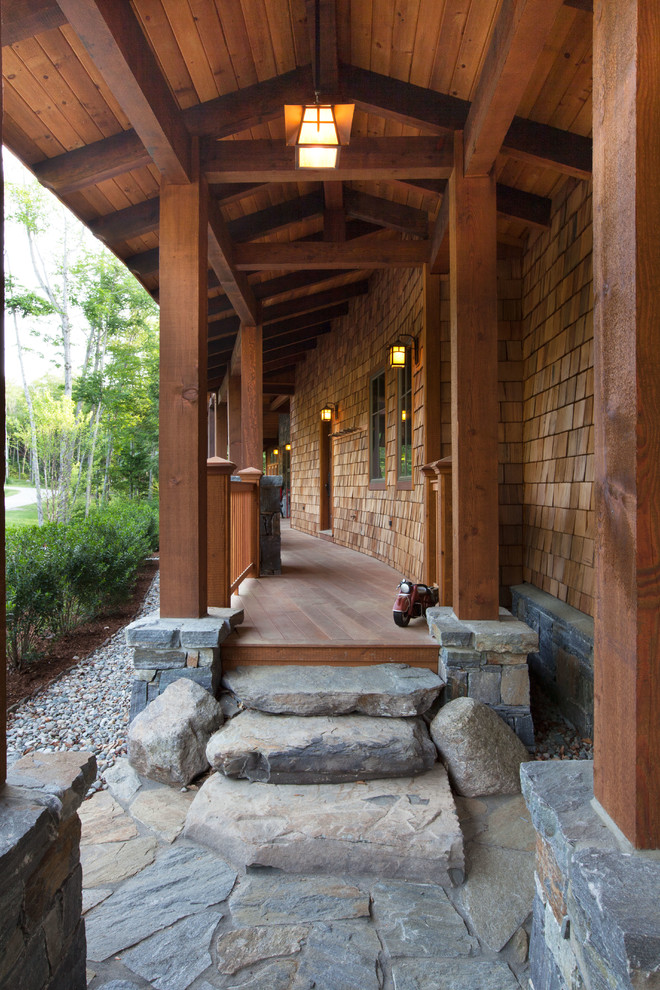 Idée de décoration pour un porche d'entrée de maison avant craftsman de taille moyenne avec une terrasse en bois et une extension de toiture.