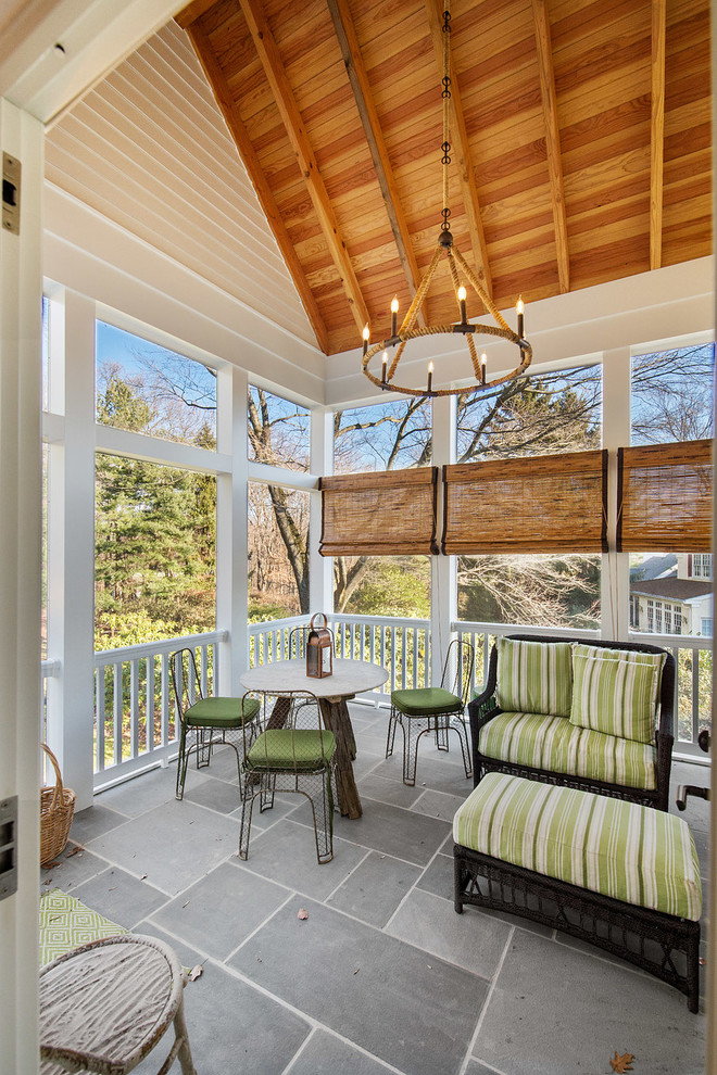 Exemple d'un porche d'entrée de maison arrière chic de taille moyenne avec des pavés en pierre naturelle et une extension de toiture.