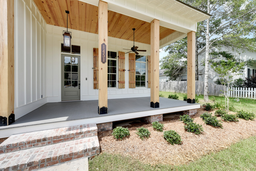 Inspiration för en mellanstor lantlig veranda framför huset, med trädäck och takförlängning