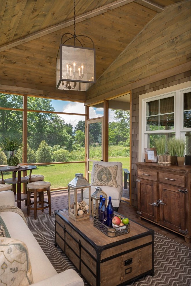 Idée de décoration pour un porche d'entrée de maison latéral chalet de taille moyenne avec une moustiquaire, une terrasse en bois et une extension de toiture.