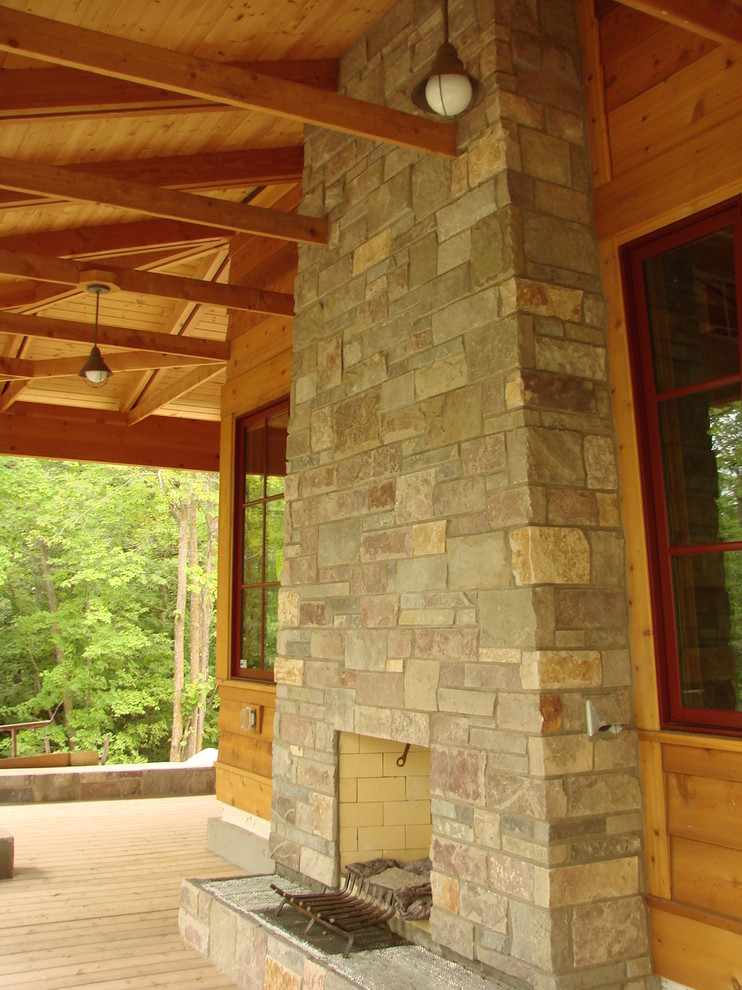 Aménagement d'un porche d'entrée de maison montagne avec un foyer extérieur.