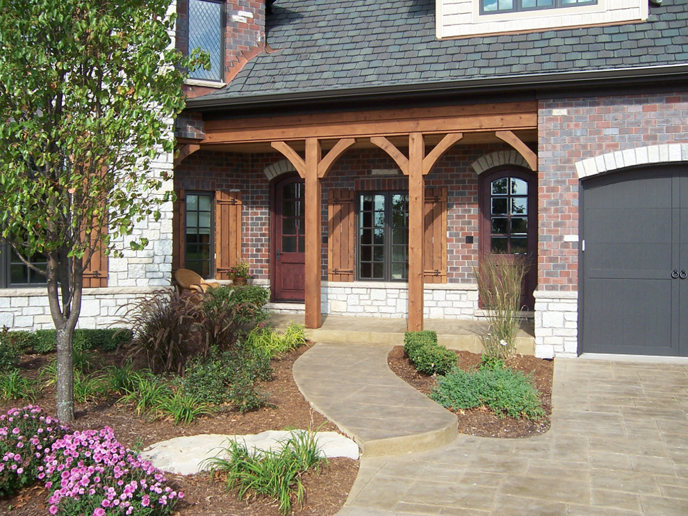 Elegant stamped concrete front porch photo in Chicago with a roof extension