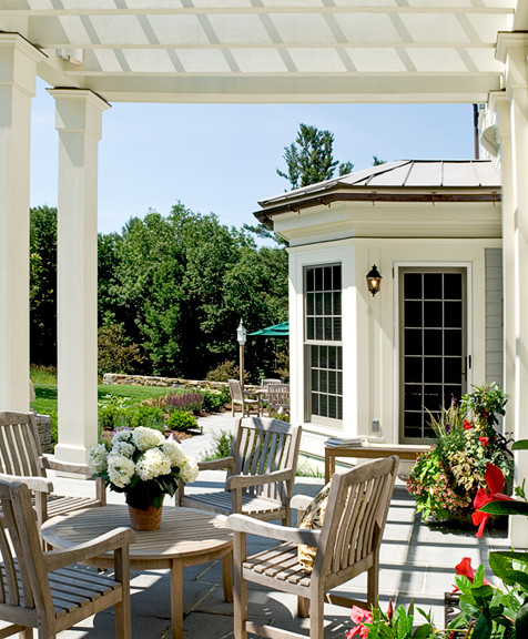Modelo de terraza clásica grande en patio delantero con losas de hormigón y toldo
