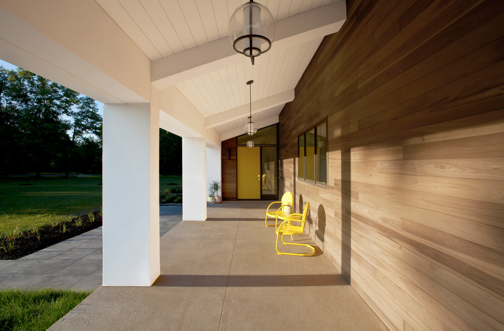 Exemple d'un porche d'entrée de maison avant rétro de taille moyenne avec une dalle de béton et une extension de toiture.