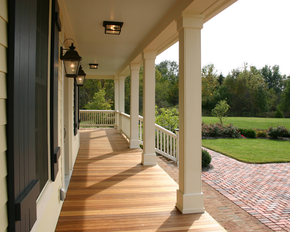 Réalisation d'un porche d'entrée de maison tradition avec une terrasse en bois et une extension de toiture.