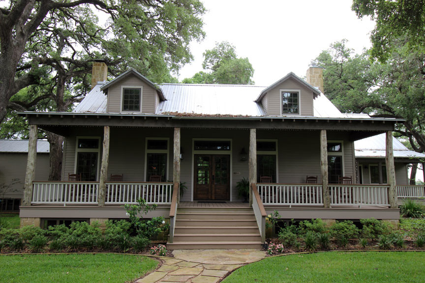 This is an example of a mid-sized cottage front porch design in Austin with decking and a roof extension.