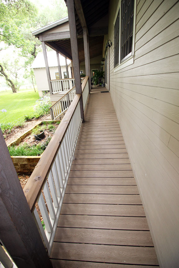 Cette photo montre un porche d'entrée de maison avant nature de taille moyenne avec une terrasse en bois et une extension de toiture.