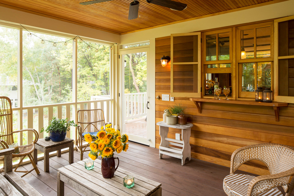 Inspiration pour un porche d'entrée de maison chalet avec une moustiquaire, une terrasse en bois et une extension de toiture.