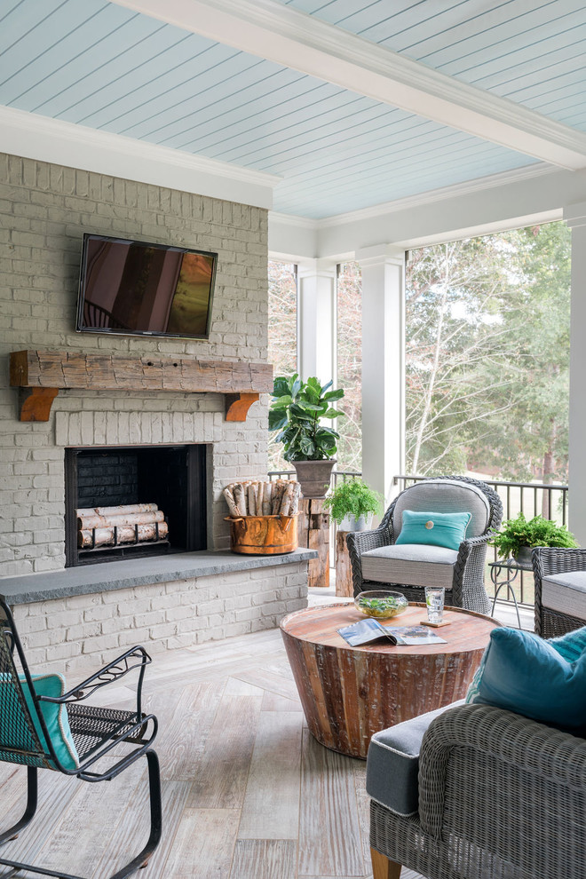 Large transitional tile back porch photo in Atlanta with a fireplace and a roof extension