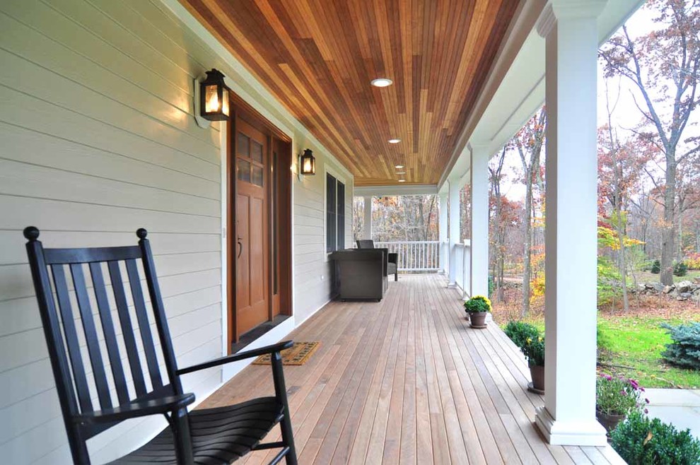 Aménagement d'un porche d'entrée de maison avant campagne de taille moyenne avec une terrasse en bois et une extension de toiture.