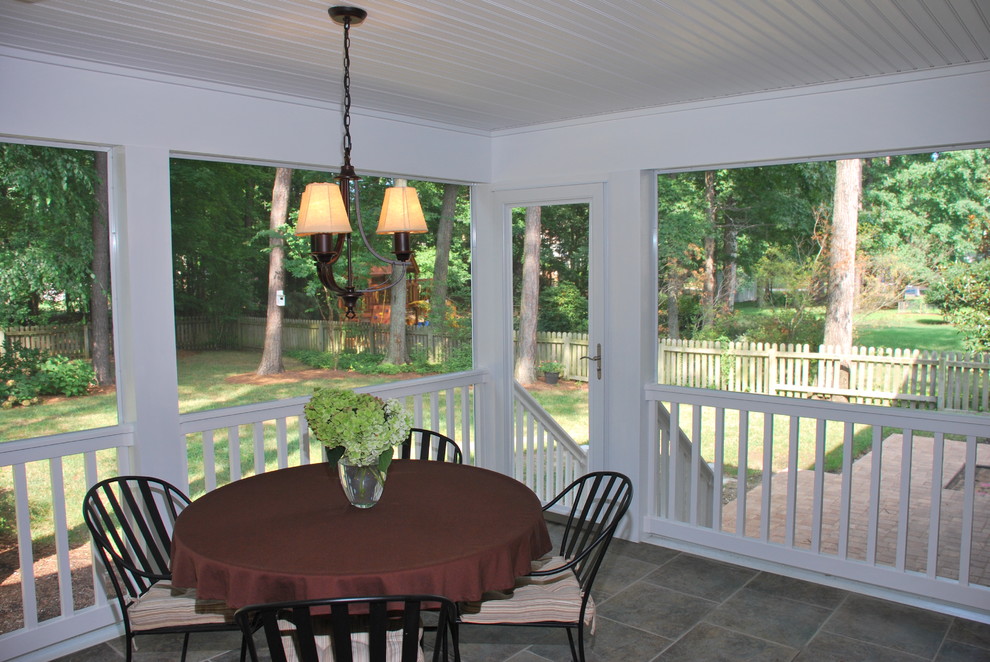 Cette photo montre un porche d'entrée de maison arrière chic de taille moyenne avec une moustiquaire, du carrelage et une extension de toiture.