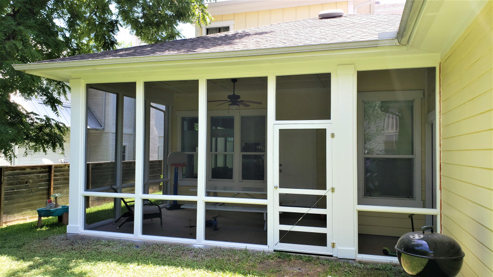 Immagine di un portico american style di medie dimensioni e dietro casa con un portico chiuso, lastre di cemento e un tetto a sbalzo