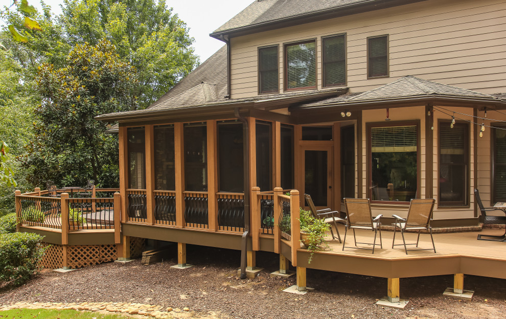 Cette image montre un grand porche d'entrée de maison arrière traditionnel avec une moustiquaire, du carrelage et une extension de toiture.