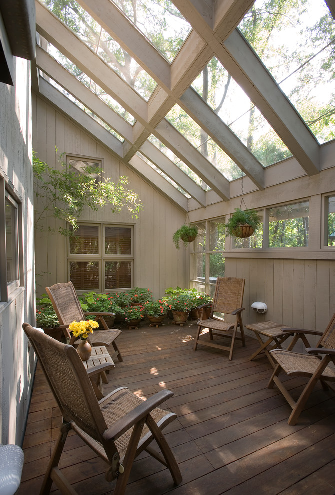 Idée de décoration pour un porche d'entrée de maison tradition avec une terrasse en bois.